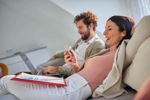 Young Caucasian Couple Sitting Casually Sofa Smiling Working Woman Looking — Stockfoto