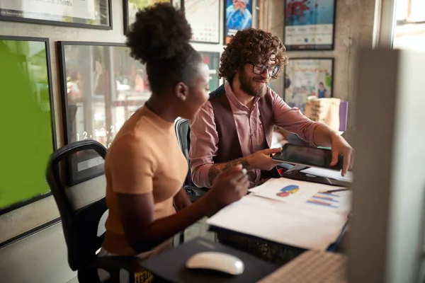 Young Man Showing Tablet Content His Female Colleague While Sitting — Stok fotoğraf