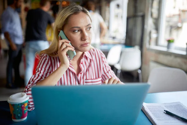 Mladá Zaměstnankyně Mluví Telefonu Zatímco Pracuje Příjemné Atmosféře Kanceláři — Stock fotografie