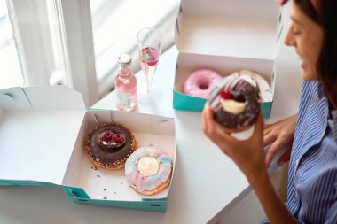 Neşeli kadın evde lezzetli çörekler yiyor.