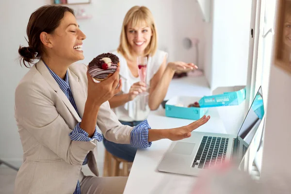 Zwei Schöne Mitarbeiterinnen Essen Zusammen Donuts Der Pause — Stockfoto