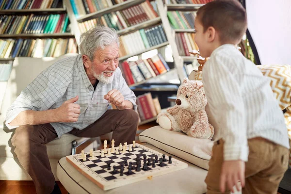 Παππούς Και Εγγονός Απολαμβάνουν Ένα Παιχνίδι Σκάκι Μια Χαρούμενη Ατμόσφαιρα — Φωτογραφία Αρχείου