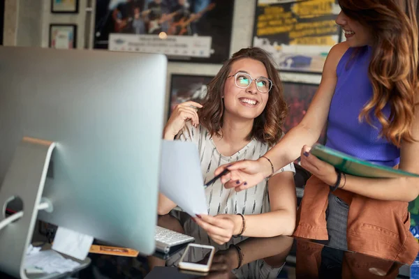 年轻的女上司用铅笔指着纸 满足了员工的要求 互相望着对方 微笑着 良好的商业关系概念 — 图库照片