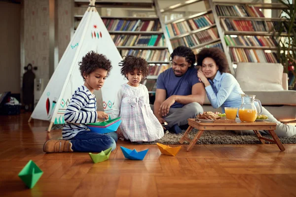孩子们一边在地板上玩纸船 一边在家里轻松地与父母共度美好时光 游戏时间 — 图库照片