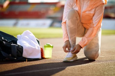 Stadyum antrenmanına hazırlanın. Koşu ayakkabısı bağlayan kadın. Spor kavramları..