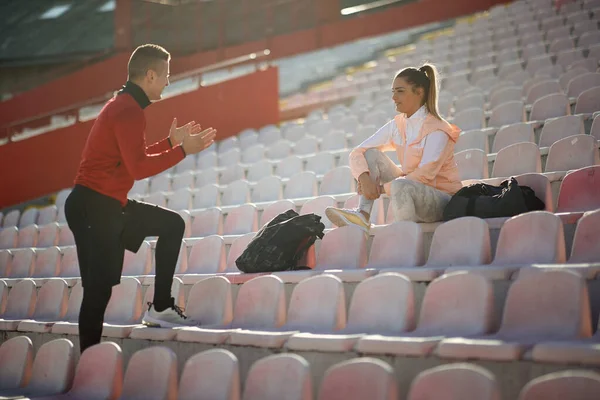 Kvinnlig Joggare Sportkläder Som Sitter Tribun Och Pratar Med Ung — Stockfoto