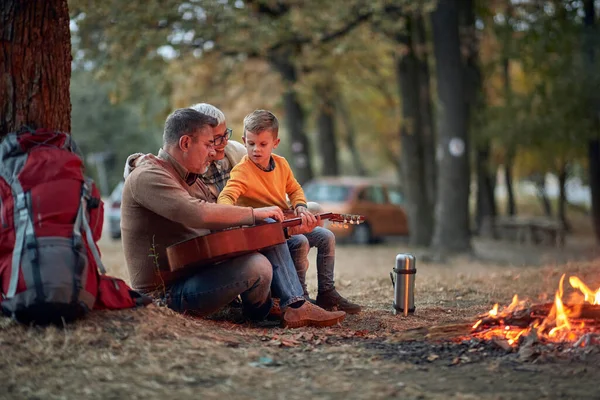 Elderly Couple Grandson Playing Guitar Forest Campfire Beautiful Autumn Dusk — Stock Photo, Image