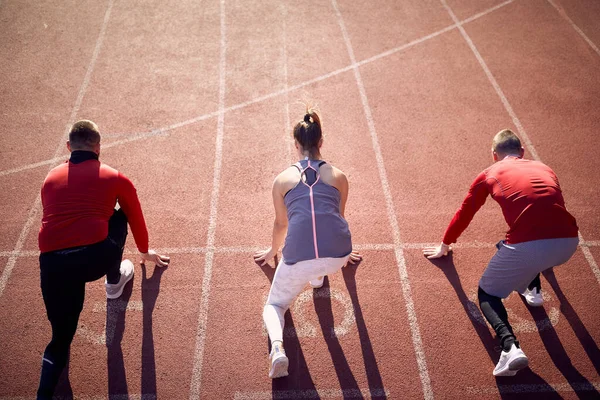 Grupp Unga Idrottare Låg Start Tävlingsbanan Träning Vacker Dag Arenan — Stockfoto