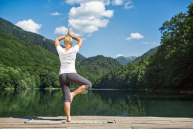 Kadın doğada meditasyon yapıyor.