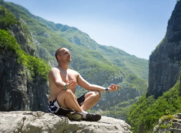 男は岩の上に座って、瞑想 — ストック写真