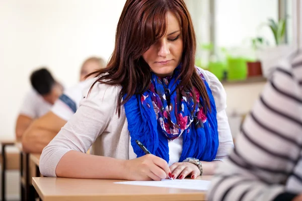 Student dziewczyna pisanie w szkole — Zdjęcie stockowe