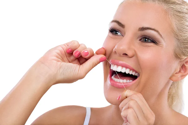 Jovem mulher usando fio dental nos dentes — Fotografia de Stock