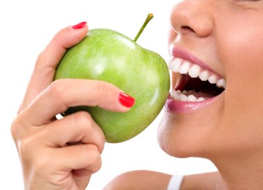 closeup of the face of a woman eating a green apple