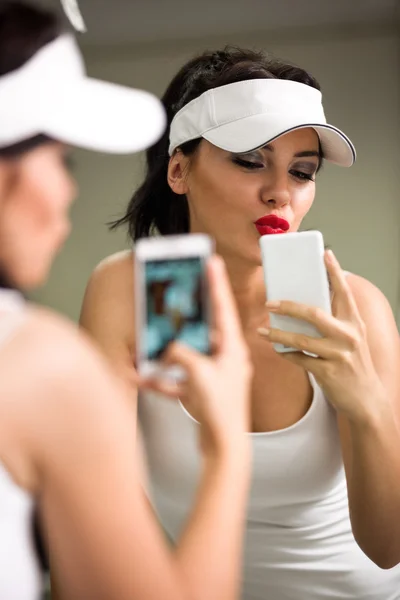 Ayna önünde bir telefon ile eğleniyor kız — Stok fotoğraf