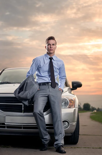 Handsome young man leaning on his car — Stock Photo, Image