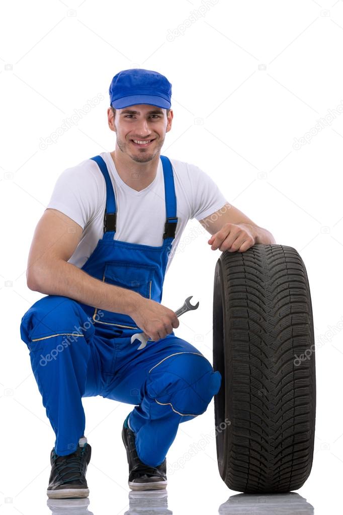 Friendly car mechanic with  tires