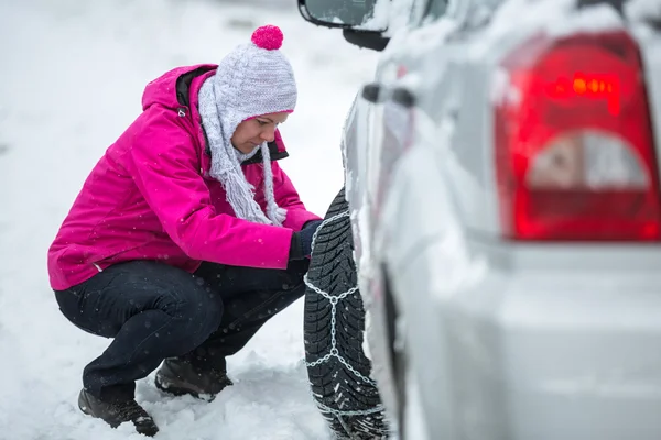 Donna mettendo catene da neve — Foto Stock