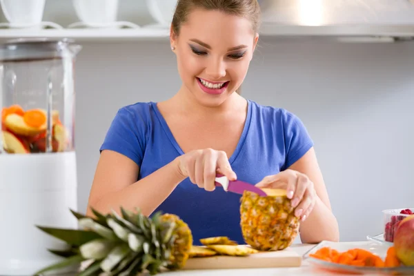 Jovem mulher sorrindo fazendo smoothies frutas com liquidificador — Fotografia de Stock