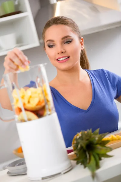 Lycklig kvinna att göra fruktjuice — Stockfoto