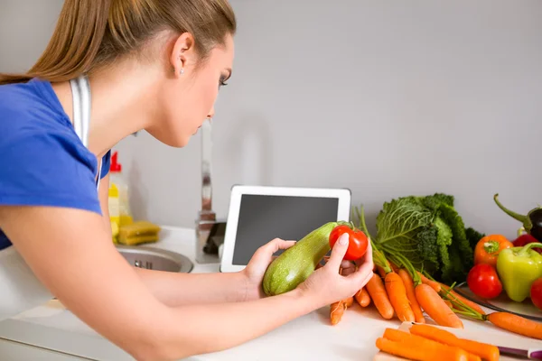 Frau in der Küche sucht Rezept im Internet — Stockfoto