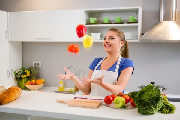 Junge Frau jongliert mit Gemüse — Stockfoto