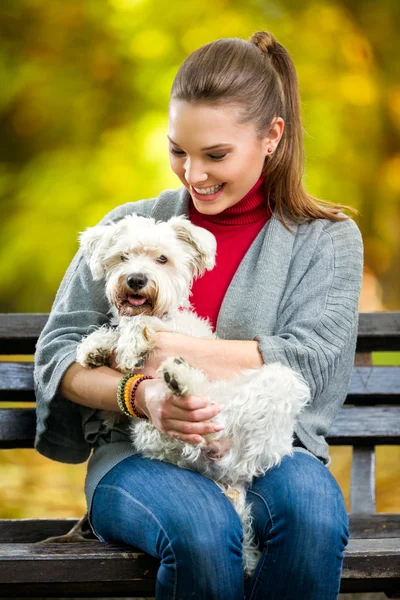 微笑女孩抱着可爱的马尔济斯犬 — 图库照片