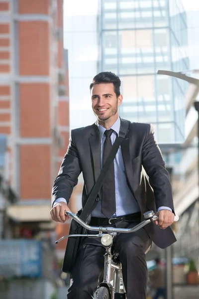 Hombre de negocios sonriente montando en bicicleta —  Fotos de Stock