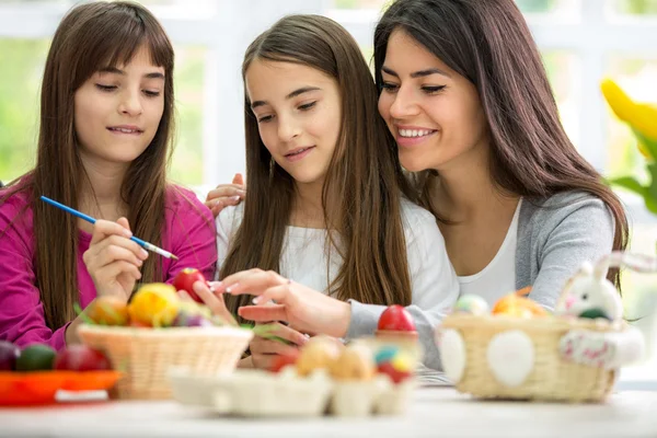 Mutter mit ihren Töchtern beim Bemalen von Ostereiern — Stockfoto