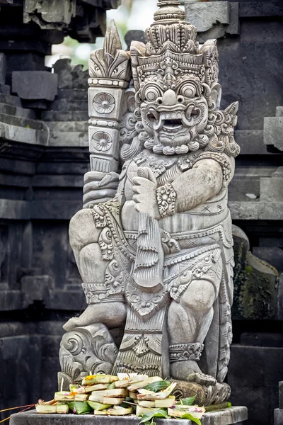Statues and carvings depicting demons or gods with offerings — Stock Photo, Image