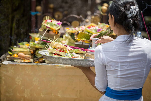 Balinese  woman carrying offering to local temple in Bali,