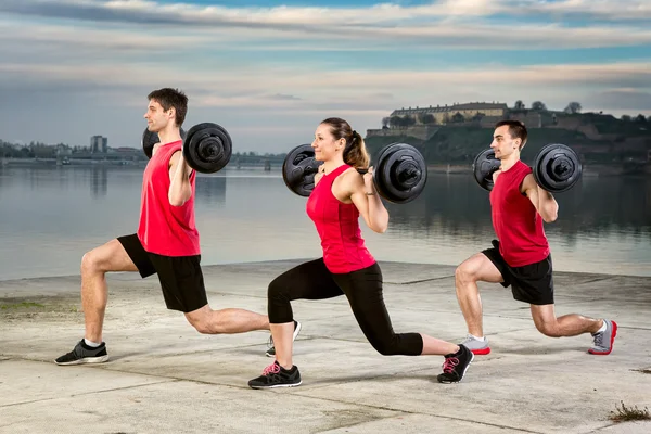 Jonge groep oppakken van barbell gewicht — Stockfoto