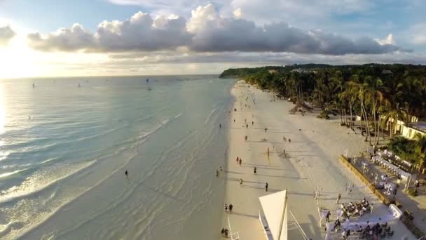 Voo aéreo sobre praia de areia, ondas e turistas — Vídeo de Stock