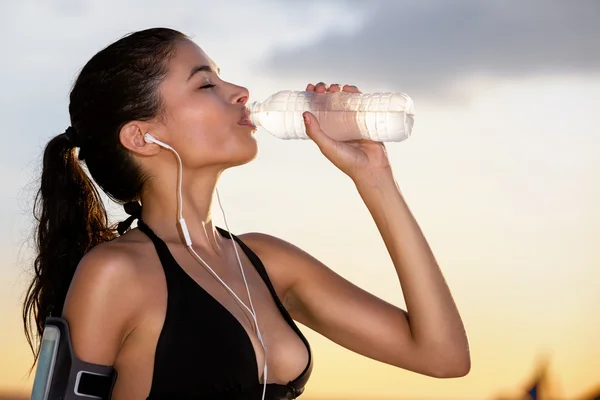 Молода спортивна жінка п'є воду — стокове фото
