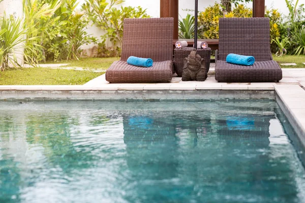 Acqua limpida blu in piscina e lettini — Foto Stock