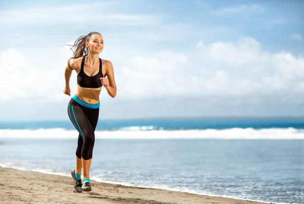 Jogging idrottsman kvinna kör på sunny beach Stockbild