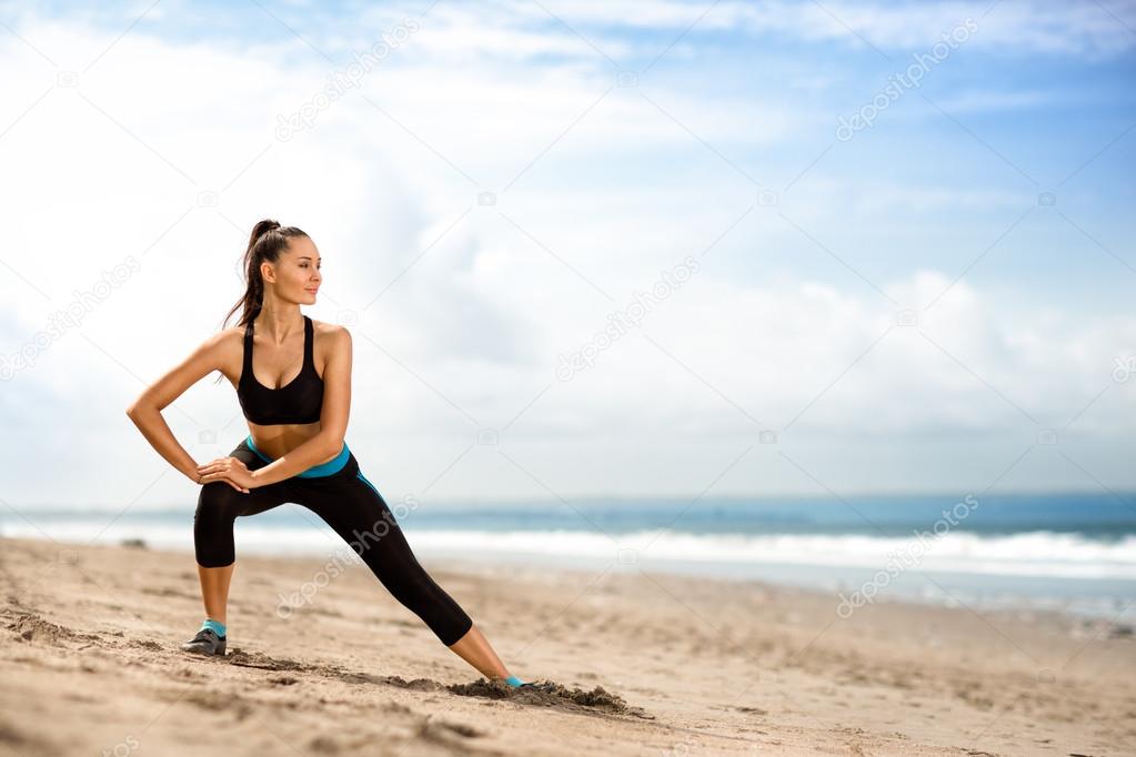 sportswoman doing exercises on beach