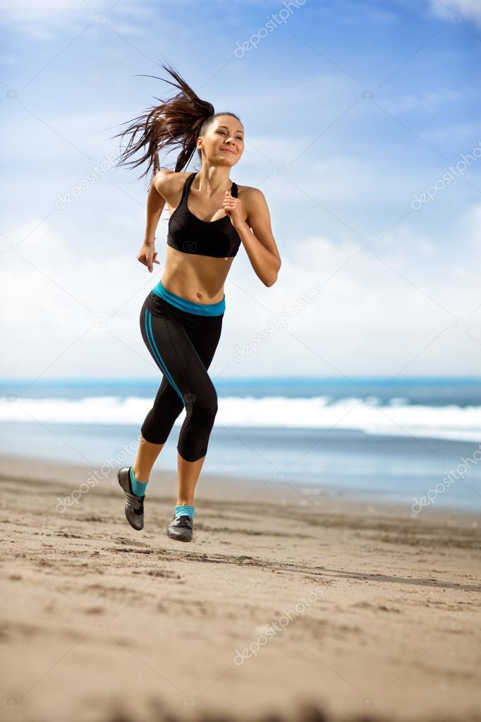 sport woman running in sea coast on sunny day