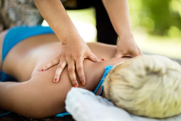 Mulher deitada e recebendo uma massagem de volta — Fotografia de Stock