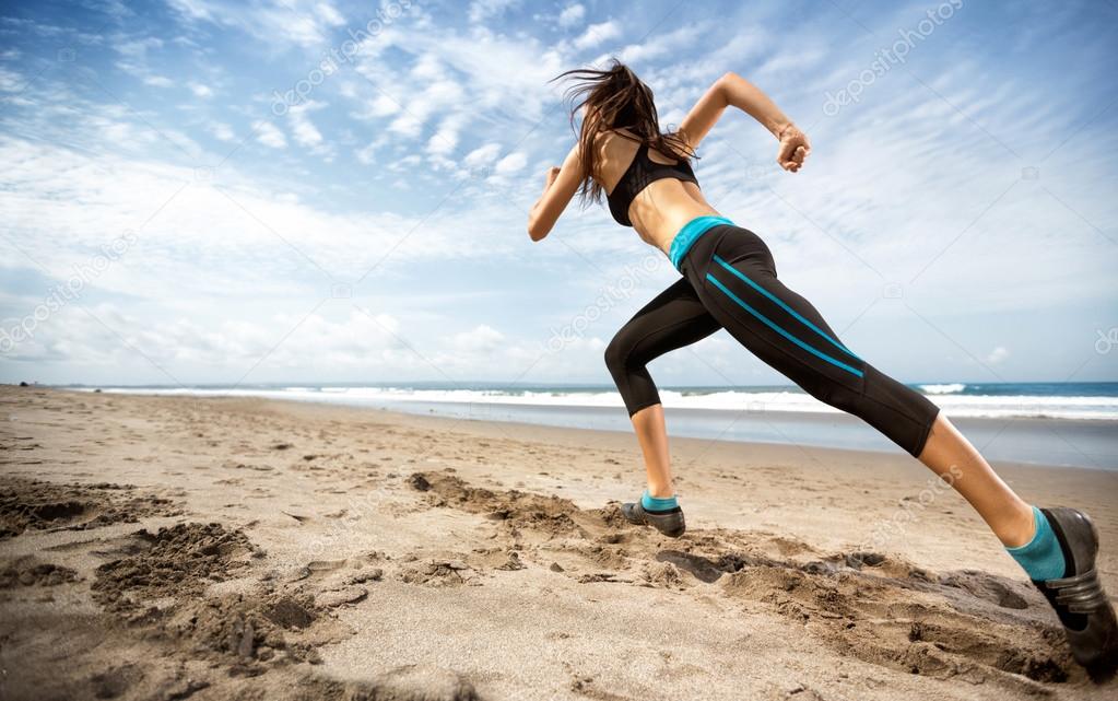 sports woman running on seaside