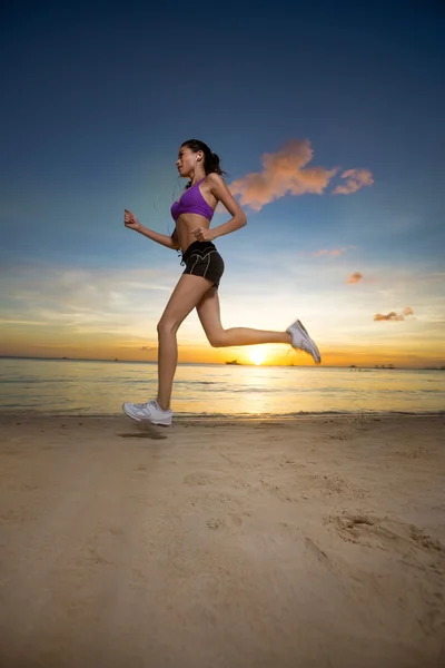 Corridore donna sulla spiaggia al tramonto — Foto Stock