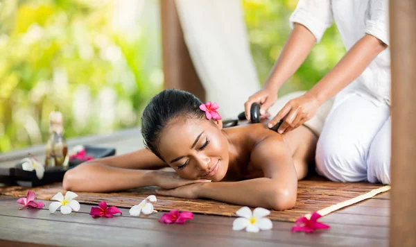 Jeune femme bénéficiant d'un massage aux pierres chaudes — Photo