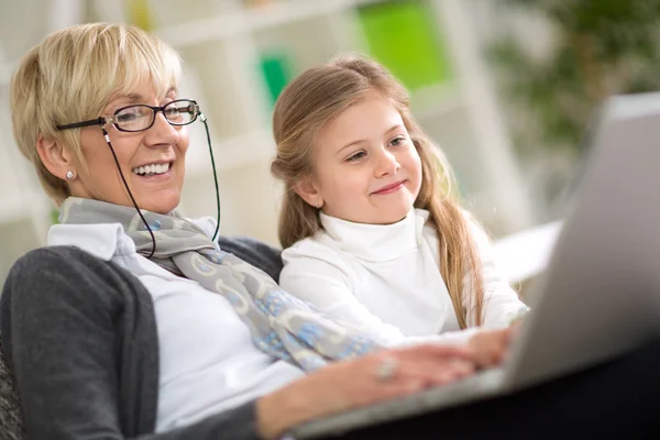 Modern grandmother teaching grandchild how to use laptop — Stock Photo, Image