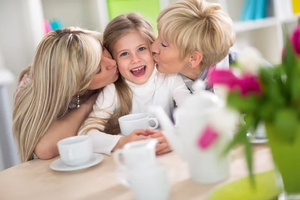 Sweet girl receiving kiss from her family — Stok fotoğraf