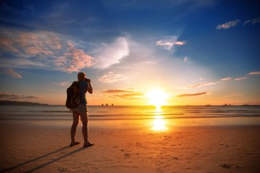 Photographer taking photo of beautiful sunset 