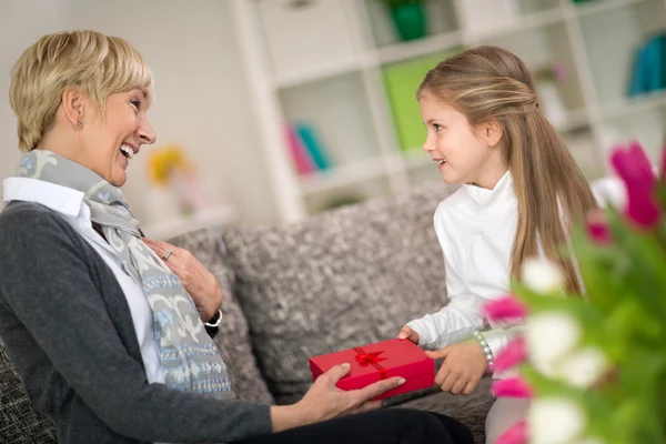 Granddaughter giving gift to her grandmother — Stock Photo, Image