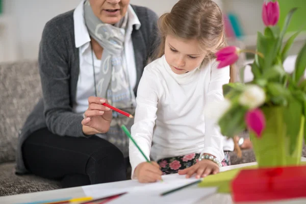 Girl doing  at homework  with the help of grandmother — 스톡 사진