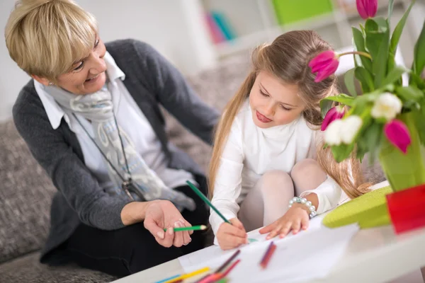 Grootmoeder helpen kleindochter met huiswerk — Stockfoto