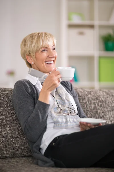Senior mulher sorrindo e bebendo chá — Fotografia de Stock