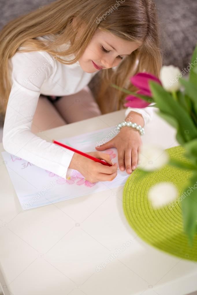 Adorable girl making gift card for mother day