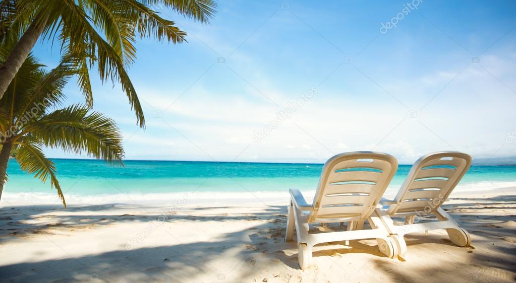 Two sunbeds on paradise beach 